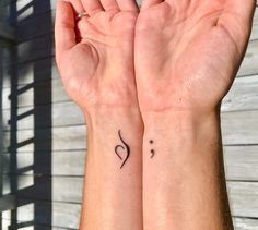 two hands holding up their wrist tattoos with the letter s on each hand and a heart in the middle