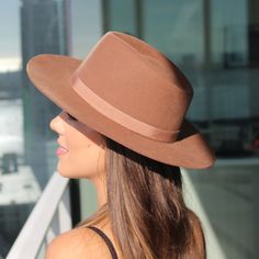 Teak brown unisex fedora hat in the Rancher style look. Sambboho's Blake hat has a hard brim and indented crown. This design has a vintage inspired silhouette with a soft grosgrain ribbon. It will provide high UV protection rated at 50+ UPF. This designer hat is very high end, handmade by our artisans with 100% Brazilian wool. This hat is unisex. You will be amazed by the quality. The timelessness chic and sophistication exuded by this hat make it a lifetime wardrobe investment you’ll never regr Western Brown Boater Hat With Flat Crown, Brown Western Boater Hat With Wide Brim, Brown Fedora With Short Brim, Classic Brown Fedora Hat, Western Style Brown Wide Brim Boater Hat, Adjustable Brown Boater Hat With Flat Crown, Brown Felt Hat With Short Brim, Brown Wide Brim Western Boater Hat, Brown Curved Brim Hat Bands For Kentucky Derby