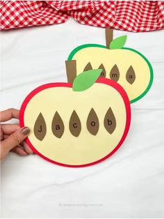 two apples cut out to spell the word abc and d