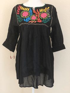 "Beautiful hand embroidered Mexican blouse. Made out of manta, 100% cotton. Color- Black/ multicolor embroidery Size: Medium Dimensions: Bust- 40\" Length - 29\"" Bohemian Cotton Blouse With Tonal Embroidery, Long Sleeve Cotton Embroidered Dress For Festivals, Traditional Cotton Blouse With Tonal Embroidery, Long Sleeve Floral Embroidered Dress For Festivals, Cotton Tunic Peasant Top For Festivals, Cotton Embroidered Long Sleeve Dress, Long Sleeve Cotton Embroidered Dress, Cotton Embroidered Top For Festival, Traditional Long Sleeve Tops With Tonal Embroidery