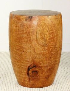 a wooden stool sitting on top of a white rug