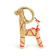 a small wooden dog made out of straw and tied with red ribbon on white background