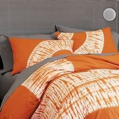 an orange and grey bed with two pillows