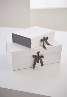 two white boxes with black bows on them