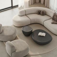 a living room filled with furniture and a book on top of a table in front of a window