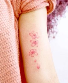 a woman's arm with pink flowers on it