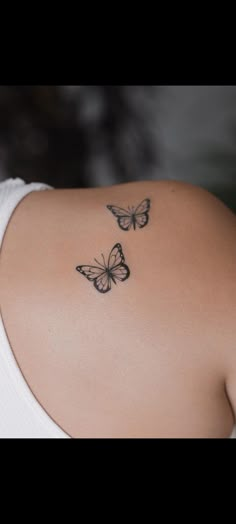 two butterflies on the back of a woman's shoulder