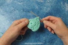 someone is crocheting an apple with yarn