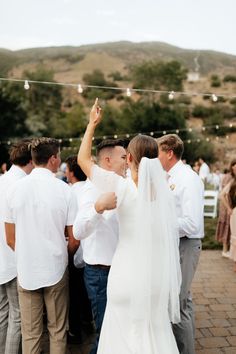 the bride and groom are dancing at their wedding reception in front of an outdoor crowd