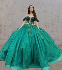 Radiate elegance and confidence in this breathtaking Emerald Green Ball-Gown Quinceanera Dress. This gown features a luxurious ball gown silhouette that flows into a majestic chapel train, ensuring a dramatic entrance that leaves a lasting impression.The stunning off-the-shoulder neckline beautifully frames your shoulders, while the sleeveless design offers freedom of movement for dancing and celebrating. It is crafted from soft tulle fabric and is adorned with intricate appliques that add textu Green Dresses Elegant, Emerald Green Ball Gown, Green Ball Gown, Gown Silhouette, Dramatic Entrance, White Homecoming Dresses, Quince Ideas, Emerald Green Dresses, Blue Homecoming Dresses