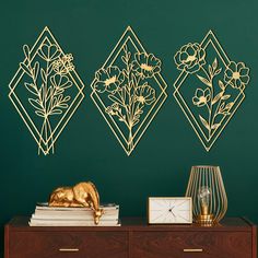 the wall is decorated with gold flowers and geometric shapes on it, along with a side table