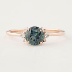 a blue diamond ring with three diamonds on the band and an oval stone in the center