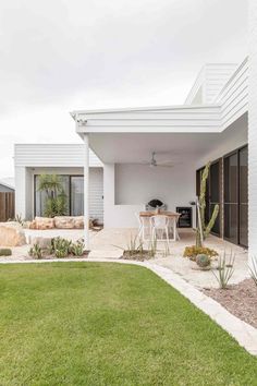 an outdoor living area with white walls and green grass