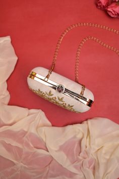 Shop a fashionable zari and pearl embroidery done box clutch bag which you can use as a clutch and a sling. It comes with a big shoulder strap in metal. It has one main compartment with a click closure and a metal bolt. Carry this bag this festive season and look glamorous. Color: ﻿Cream White Material: Silk Size: 7 inch X 7 inch Care: Wipe with a dry cloth Luxury Evening Shoulder Bag With Zari Work, Luxury Rectangular Cream Evening Bag, Luxury Cream Bags For Wedding, Luxury White Chic Pouch, Luxury White Bag With Embroidered Logo, Luxury Pearl-embroidered Pouch Evening Bag, Luxury Cream Embellished Bag, Luxury Zari Work Party Shoulder Bag, Luxury White Bag For Reception