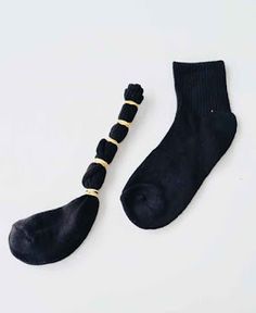 two pairs of black socks and one pair of gold toenails on white background