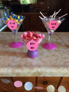 two martini glasses filled with candy on top of a counter