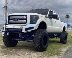 a white truck parked on top of a grass covered field