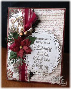 a christmas card with poinsettis and ribbon on the front, sitting on a table