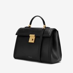 A larger iteration of The Paris, The Midi Paris is a cosmopolitan top handle bag that showcases our unwavering commitment to craftsmanship. Each one is ethically handmade from sustainable Italian leather and is exquisitely framed with a bombée trim. It features a new trunk inspired gold-plated lock, as well as a detachable and adjustable leather strap for further styling options. The soft cotton-lined interior is capacious enough for all daily essentials. The Midi Paris is inspired by the timele High-end Rectangular Bags For Work, High-end Everyday Flap Bag With Double Handle, High-end Everyday Double Handle Flap Bag, High-end Double Handle Flap Bag For Everyday, High-end Everyday Top Handle Satchel, High-end Everyday Satchel With Top Handle, High-end Office Tote Flap Bag, Elegant Shoulder Bag With Round Handle For Work, Modern Workwear Briefcase With Handle Drop