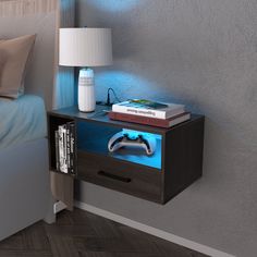 a nightstand with a video game controller on it next to a night stand and lamp