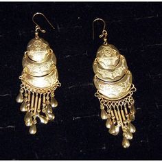 Half-moon gold earrings etched with the image of villagers and animals. Traditional Gold Metal Clip-on Earrings, Ornate Bronze Earrings, Antique Ceremonial Earrings, Antique Gold Earrings For Festivals, Engraved Metal Drop Earrings, Gold Etched Drop Earrings, Traditional Round Engraved Earrings, Traditional Engraved Round Earrings, Vintage Brass Earrings With Latkans