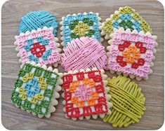 four decorated cookies sitting on top of a wooden table next to some string and yarn