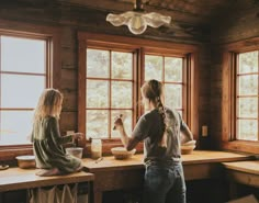 two women sitting at a kitchen counter preparing food