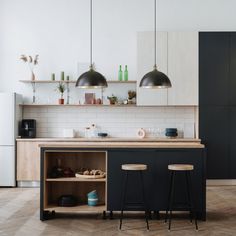 an open kitchen with two stools next to the counter