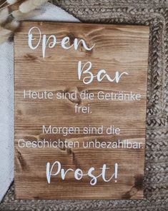 an open bar sign on the side of a wall next to a piece of wood