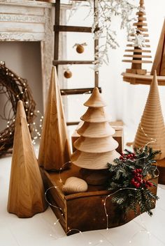 wooden christmas trees on display in front of a fireplace