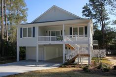 a two story white house in the woods