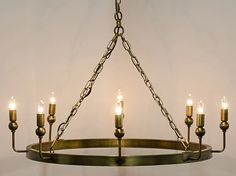 a chandelier with six lit candles hanging from it's center ring, on a white background