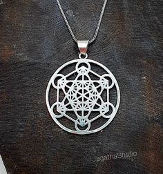 HANDMADE Beautiful Metatron's Cube  pendant with a complementary decorated chain. Metatron's Cube includes all 5 Platonic Solids hidden inside, symbolizing the underlying geometric patterns found throughout our universe. ... It's named after Archangel Metatron, who watches over the flow of energy in creation and provides a connection to the divine. Made by hand with hight quality of brass, Nickel free.  Aprox Heigh pendant: 4.9 cm Aprox Diameter pendant: 3.8 cm Aprox optional chain Lenght: 44 cm Cube Pendant, Platonic Solids, Archangel Metatron, Metatron's Cube, Metatrons Cube, Platonic Solid, Our Universe, Tourmaline Pendant, Bohemian Necklace