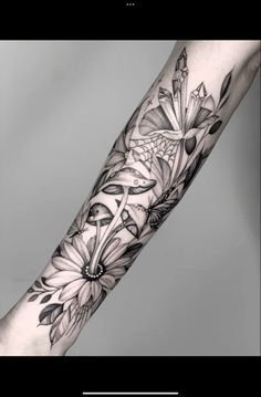 a woman's arm with black and white flowers on the left side of her arm