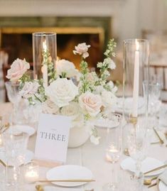 the table is set with white flowers and candles