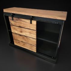 a wooden cabinet with black metal handles and drawers on the bottom, against a dark background