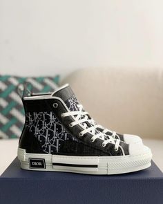 Embrace a blend of classic and contemporary style with these high-top sneakers inspired by the iconic Dior B23. Featuring a sleek black upper adorned with the signature Dior Oblique pattern, these shoes exude understated luxury. The contrasting white sole with a black stripe adds a sporty touch, while the high-top silhouette provides ankle support and a fashion-forward edge. Modern Medium Fit High-top Sneakers For Streetwear, Luxury High-top Sneakers With Contrast Sole, Designer High-top Sneakers With Contrast Sole, Luxury High-top Sneakers With Contrast Sole For Streetwear, Luxury High-top Sneakers With Branded Insole, Luxury High-top Lace-up Sneakers With Boost Midsole, Luxury High-top Sneakers With Boost Midsole For Streetwear, Luxury Lace-up High-top Sneakers With Boost Midsole, Luxury Lace-up High-top Sneakers With Contrast Sole