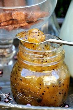 a jar filled with food sitting on top of a metal tray next to a glass bowl