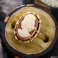 This sweet ring holds an oval shell cameo in a bezel setting, with a decorated goldwork frame. The ring is crafted in 10k yellow gold and currently fits a size 2.75. This ring will likely have limitations for how many sizes it can increase, so please feel free to call with sizing inquiries. Luxury Heirloom Jewelry With Fluted Bezel, Elegant Luxury Oval Cabochon Dome Ring, Luxury Vintage Oval Cabochon Dome Ring, Bezel Set Cabochon, Sweet Ring, Cameo Ring, Gold Work, Yellow Gold Rings, Bezel Setting