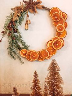 orange slices arranged in the shape of a wreath with bells and pine trees around it