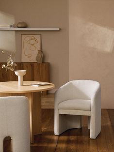 a white chair sitting next to a table on top of a hard wood floored floor