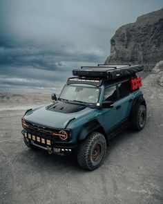 a blue truck parked on top of a dirt field