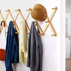 a coat rack with hats and coats hanging from it's hooks on the wall