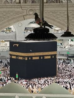 a large group of people gathered around the kabab in the grand mosque,