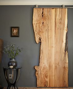 a large wooden piece of wood sitting on top of a hard wood floor next to a table