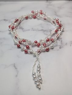 Elevate your style with our long boho pearl beaded crochet necklace. Handmade with intricate crochet work, this multilayered piece features a harmonious blend of white and red beads, perfect for making any outfit pop. The necklace offers a versatile look for both casual and formal settings, adding a chic bohemian touch to your ensemble. Lightweight and comfortable, it's ideal for everyday wear or as a unique gift for someone special. Complete your jewelry collection with this stunning, eye-catching piece that'll surely garner compliments. This simple design has a blend of elegance and boho chic makes it easy to dress up or down for any occasion. Measuring 72 inches this beautiful tie-on choker/necklace is great for work or play, is the perfect accessory to your wardrobe. buy it for yoursel White Beaded Lariat Necklace, Bohemian Crochet Jewelry With Round Beads, Handmade Bohemian Lariat Pearl Necklace, White Beaded Bohemian Lariat Necklace, Bohemian Lariat Pearl Jewelry, Adjustable Multi-strand Bohemian Pearl Necklace, Bohemian Beaded Pearl Necklace, White Bohemian Beaded Lariat Necklace, Handmade Bohemian Pearl Beads