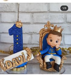 two figurines sitting on top of a table next to a number one ornament