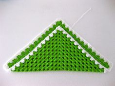 a crocheted green and white triangle