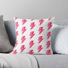 a white couch with pink and red lightning bolt pillows on it's back side