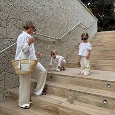 an older woman and two young children are on the stairs